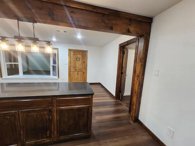 a large kitchen with stainless steel appliances wooden floors and wooden cabinets