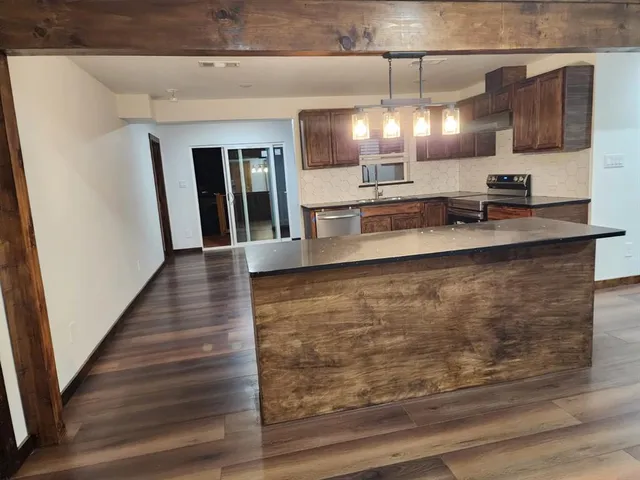 a kitchen with stainless steel appliances granite countertop a sink and white cabinets