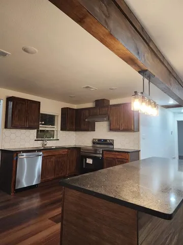 a kitchen with stainless steel appliances granite countertop a stove a sink and a refrigerator