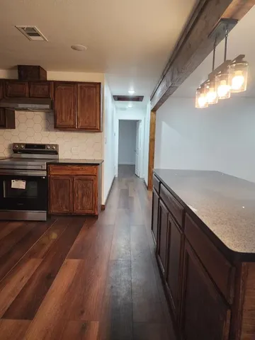 a kitchen with stainless steel appliances granite countertop wooden cabinets stove top oven and sink