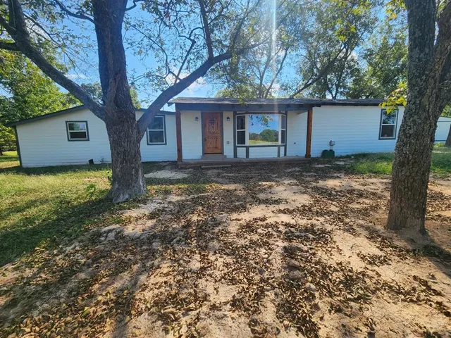 a view of a house with a tree in the yard