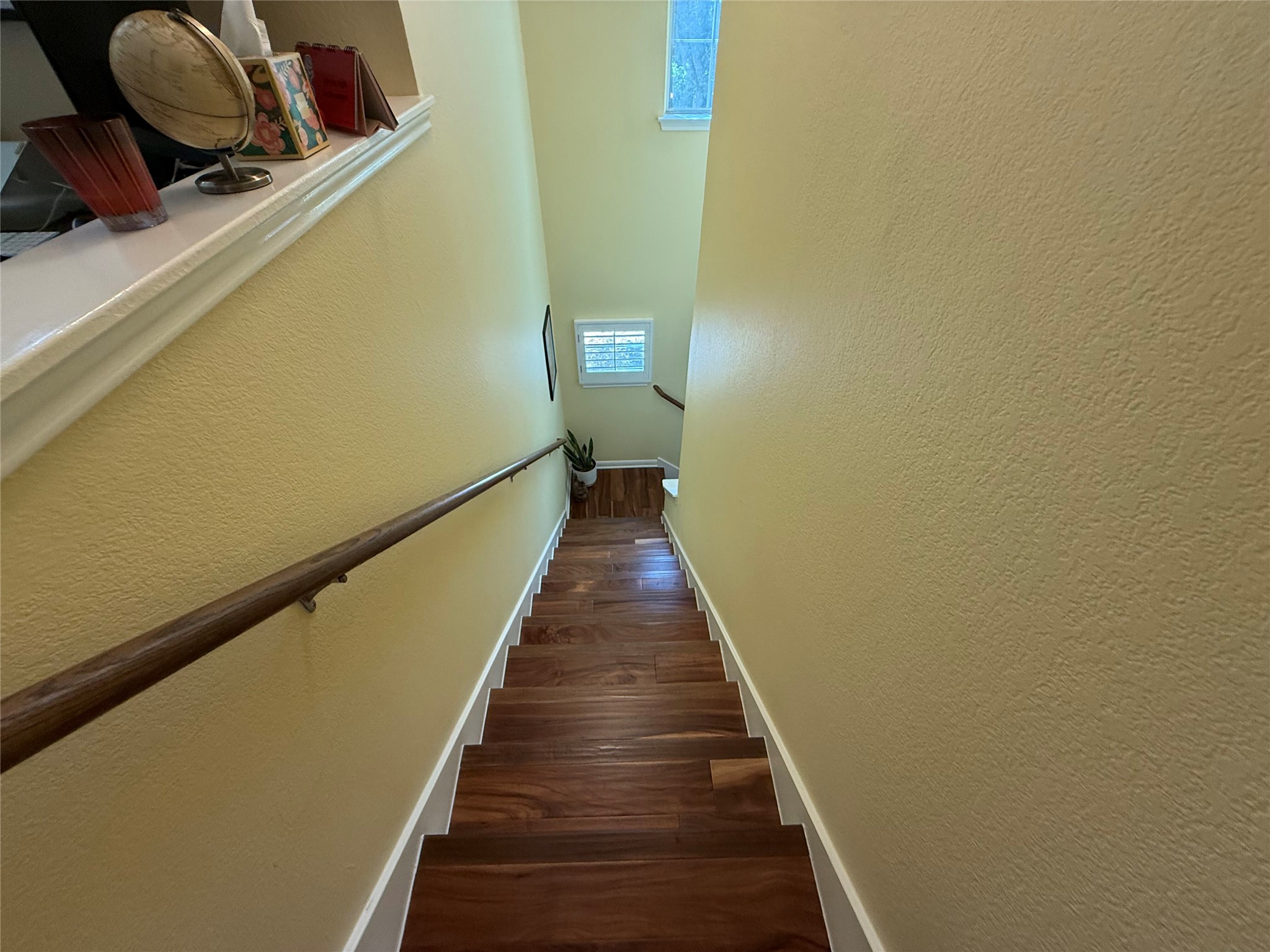 11000 Anderson Mill Road, Unit 93 Austin, TX 78750 - Photo 9 of 27 Rich hardwood stairs descend gracefully, offering a warm and inviting pathway to the lower level.