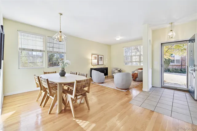a dining room with furniture a chandelier and wooden floor