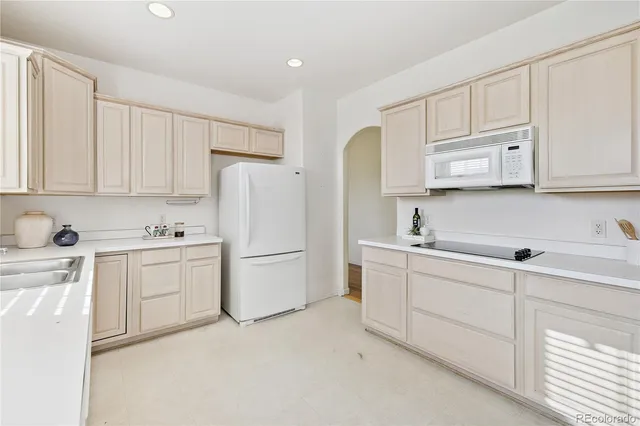 a kitchen with white cabinets white stainless steel appliances and sink