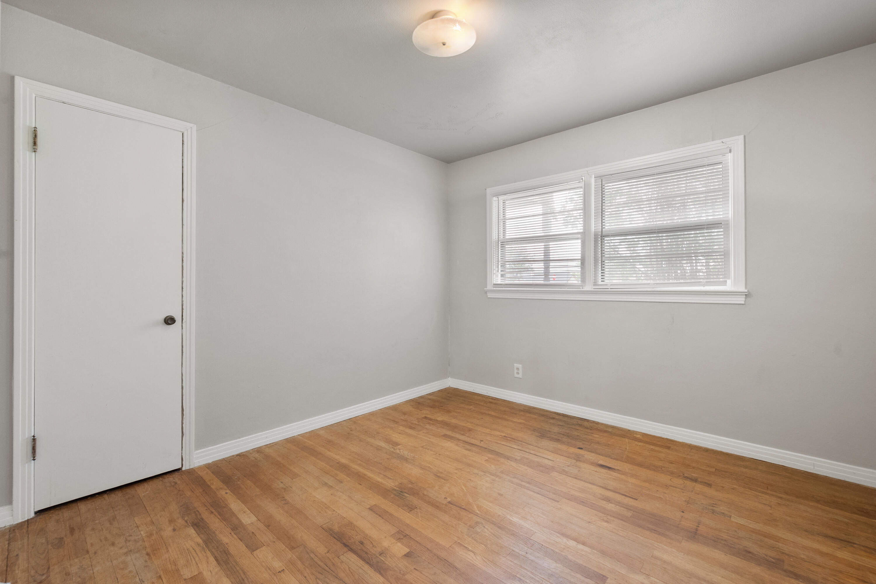 811 Zephyr Plainview, TX 79072 - Photo 16 of 25 an empty room with wooden floor and windows