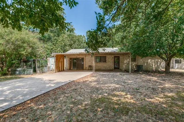 a front view of a house with a garden and trees