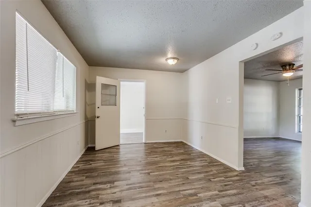 a view of a hallway with wooden floor and a living room