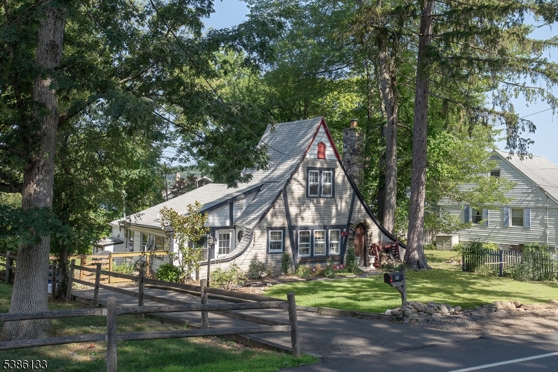 a view of a house next to a yard with plants and trees