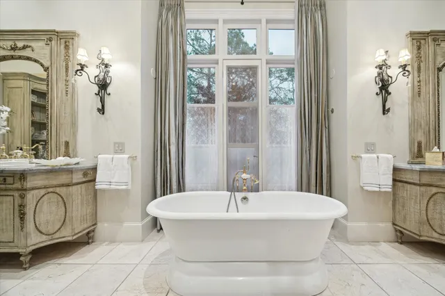 a bathroom with a tub a sink and a mirror