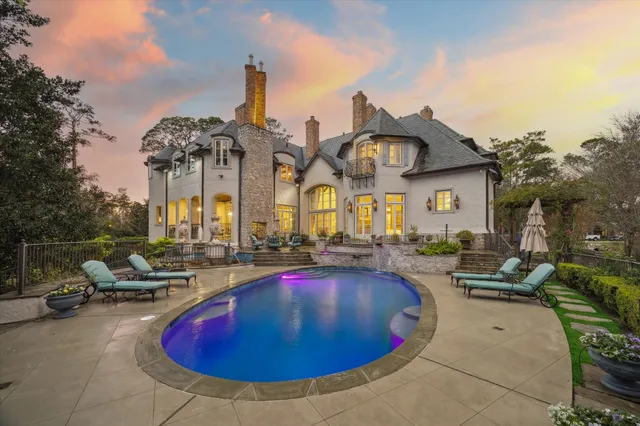 a view of a house with swimming pool and sitting area