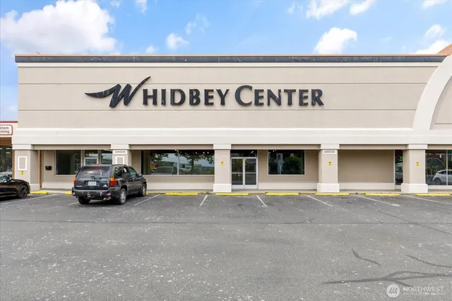 a view of a building with car parked on the road