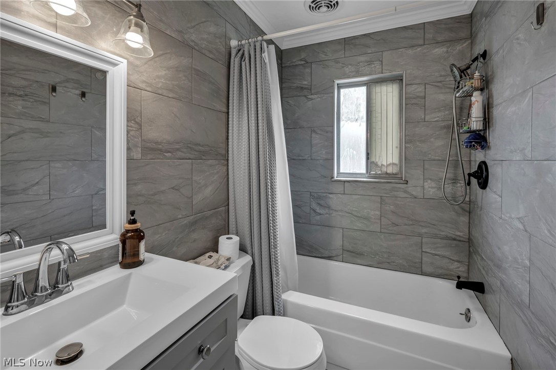 5200 Royalton Road, Unit 9B North Royalton, OH 44133 - Photo 23 of 27 Bathroom featuring crown molding, vanity, shower / bath combo, and tile walls