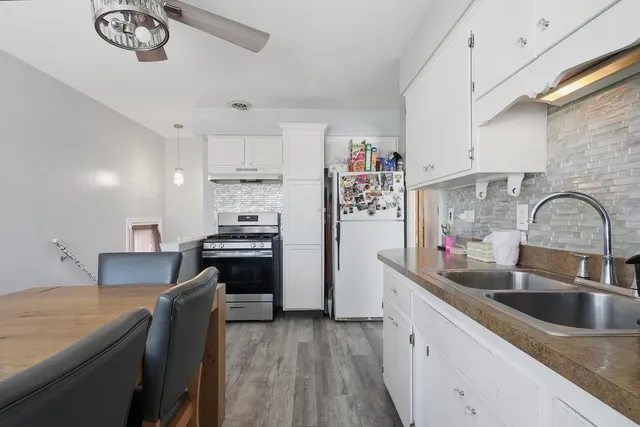 a kitchen with kitchen island a sink appliances and cabinets