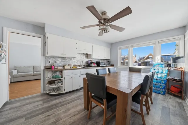 a kitchen with a dining table chairs and white cabinets