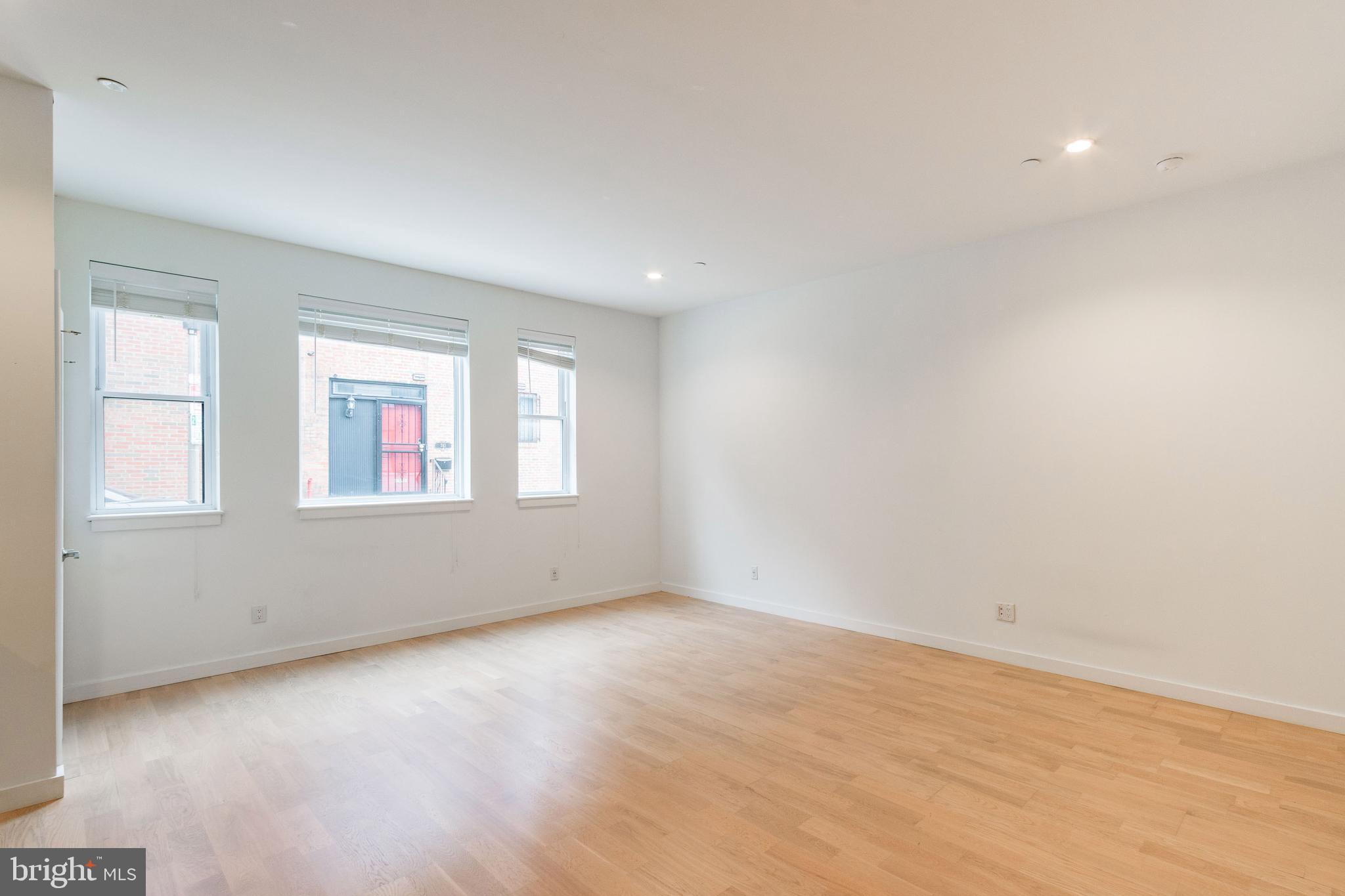 507 South 8th Street, Unit 102 Philadelphia, PA 19147 - Photo 2 of 10 an empty room with wooden floor and windows