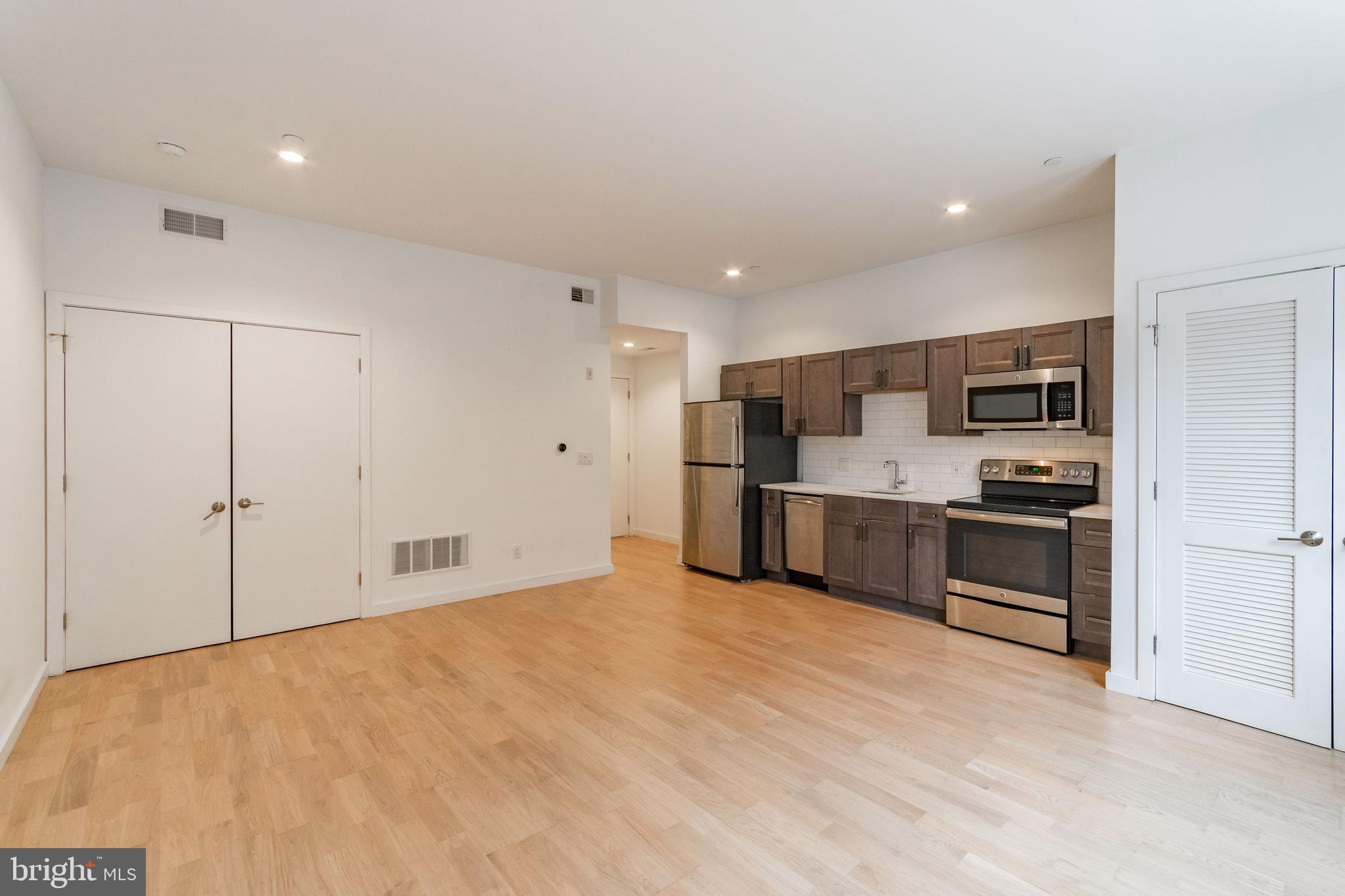 507 South 8th Street, Unit 102 Philadelphia, PA 19147 - Photo 4 of 10 a view of kitchen with stainless steel appliances kitchen island granite countertop a stove top oven a sink and a refrigerator