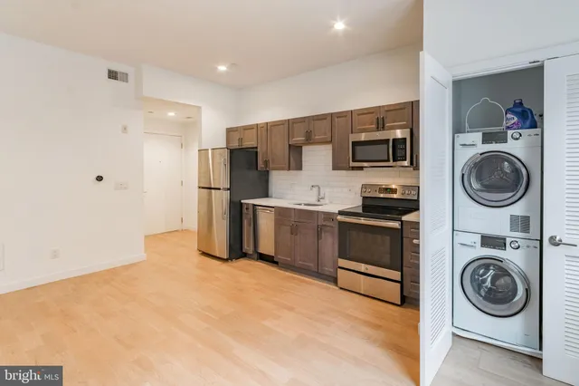 a kitchen with stainless steel appliances granite countertop a refrigerator and a stove top oven