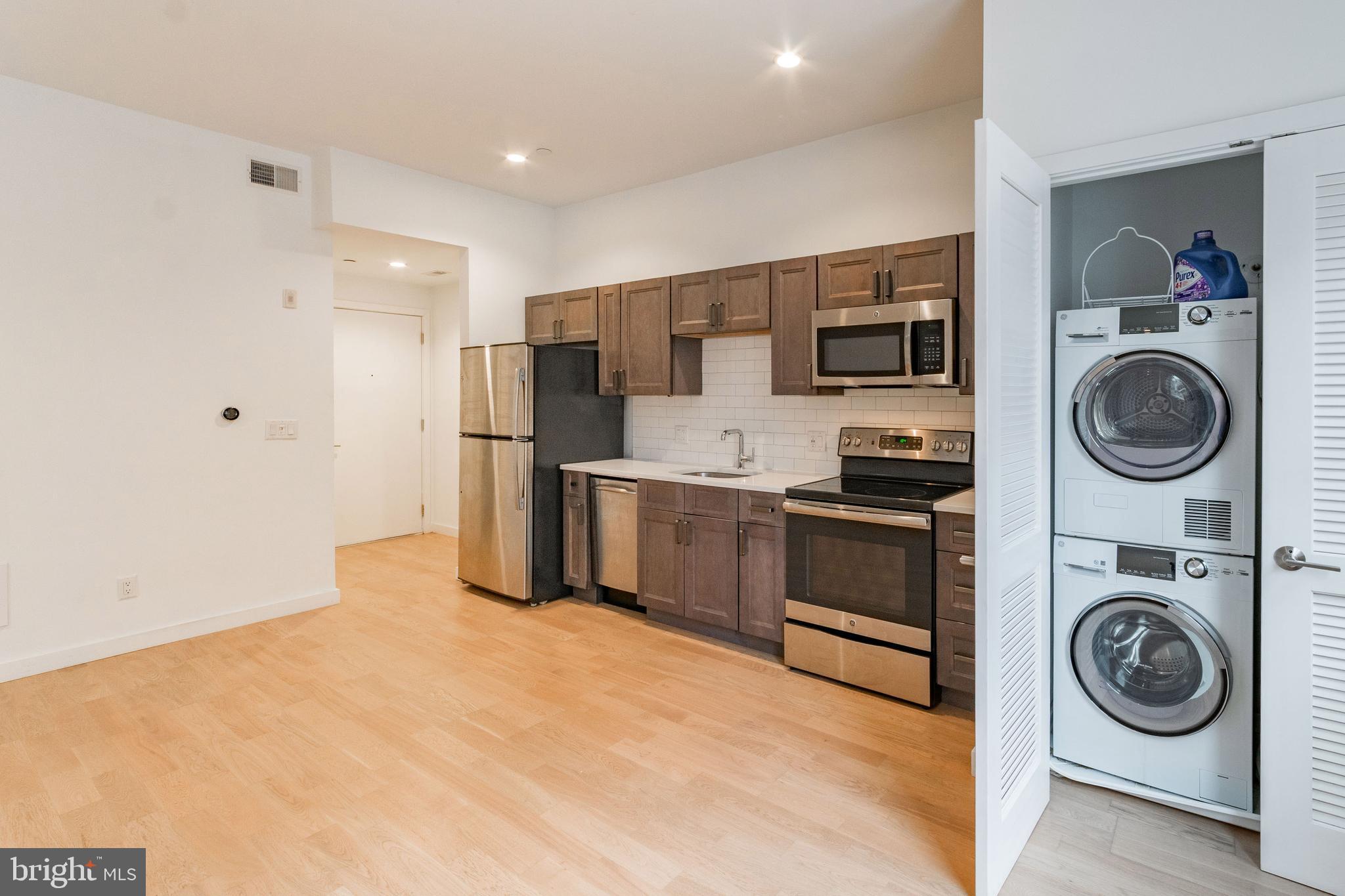 507 South 8th Street, Unit 102 Philadelphia, PA 19147 - Photo 5 of 10 a kitchen with stainless steel appliances granite countertop a refrigerator and a stove top oven