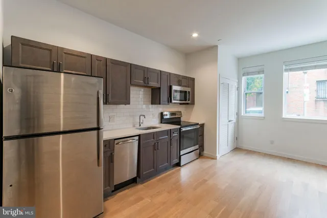 a kitchen with stainless steel appliances a refrigerator and a stove top oven