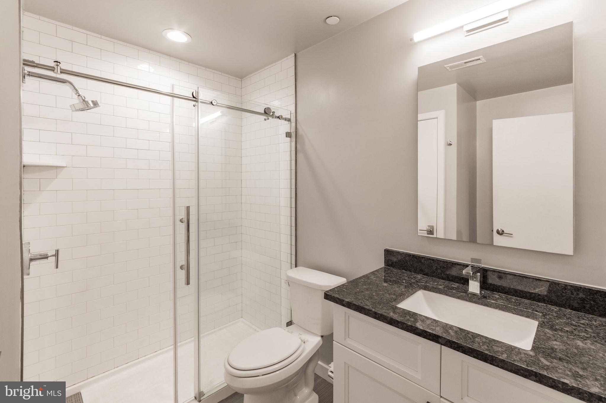 507 South 8th Street, Unit 102 Philadelphia, PA 19147 - Photo 8 of 10 a bathroom with a granite countertop sink toilet and shower