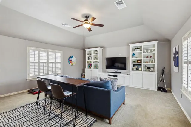 a living room with furniture ceiling fan and a window