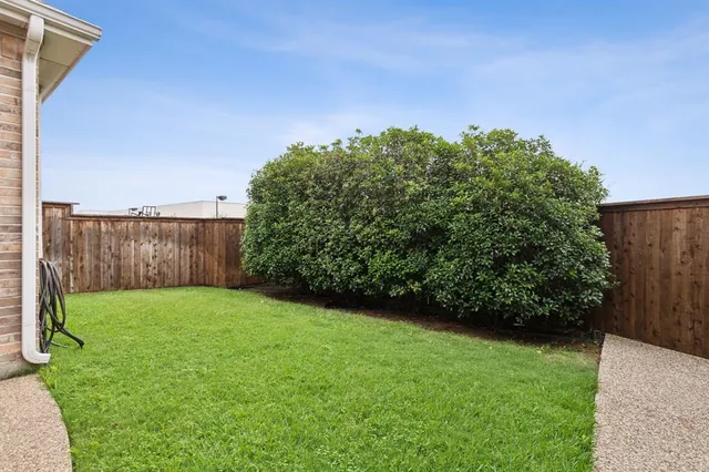 a backyard of a house with table and chairs