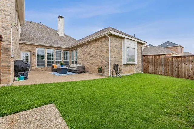 a front view of a house with a yard and tree