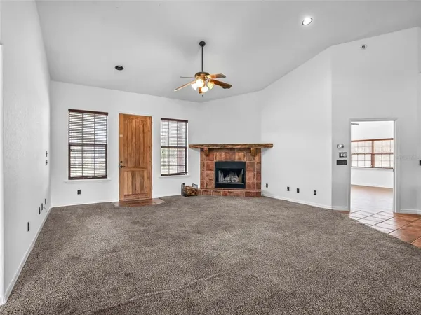 an empty room with windows and fireplace