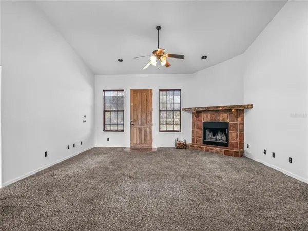 an empty room with fireplace and windows