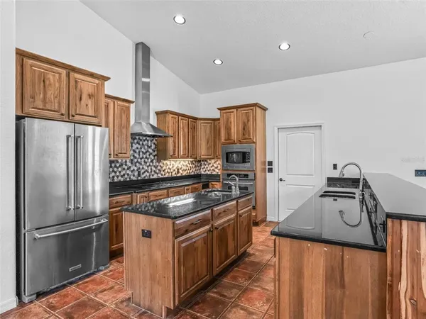 a kitchen with granite countertop a sink and a stove top oven