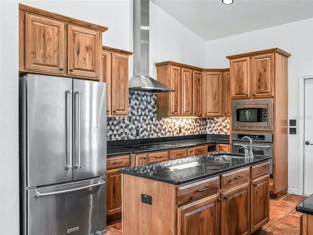 a kitchen with granite countertop a sink and white cabinets