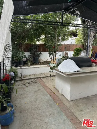 a view of a patio with table and chairs potted plants