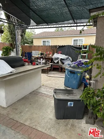 a view of a patio with table and chairs potted plants