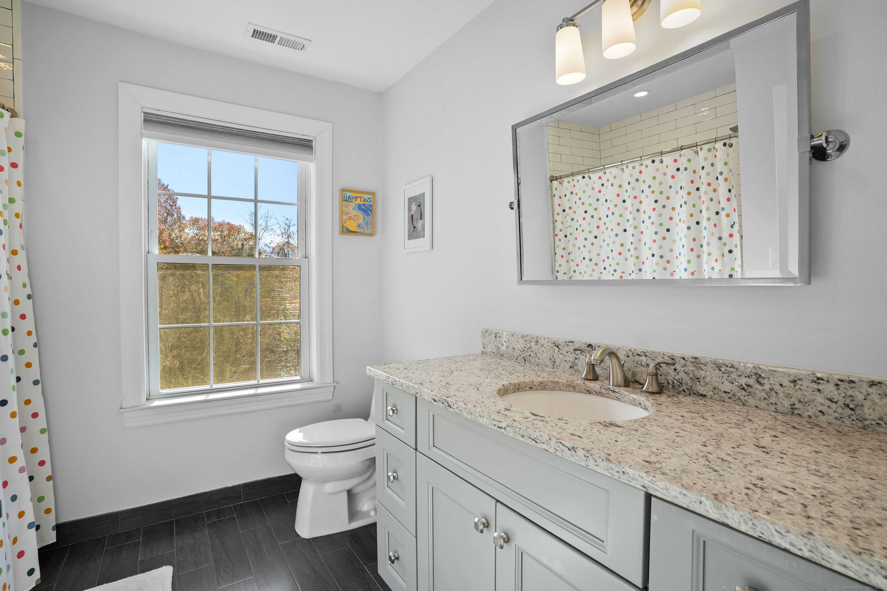 100 Hirsch Road Stamford, CT 06905 - Photo 31 of 39 a bathroom with a granite countertop sink a toilet and a window