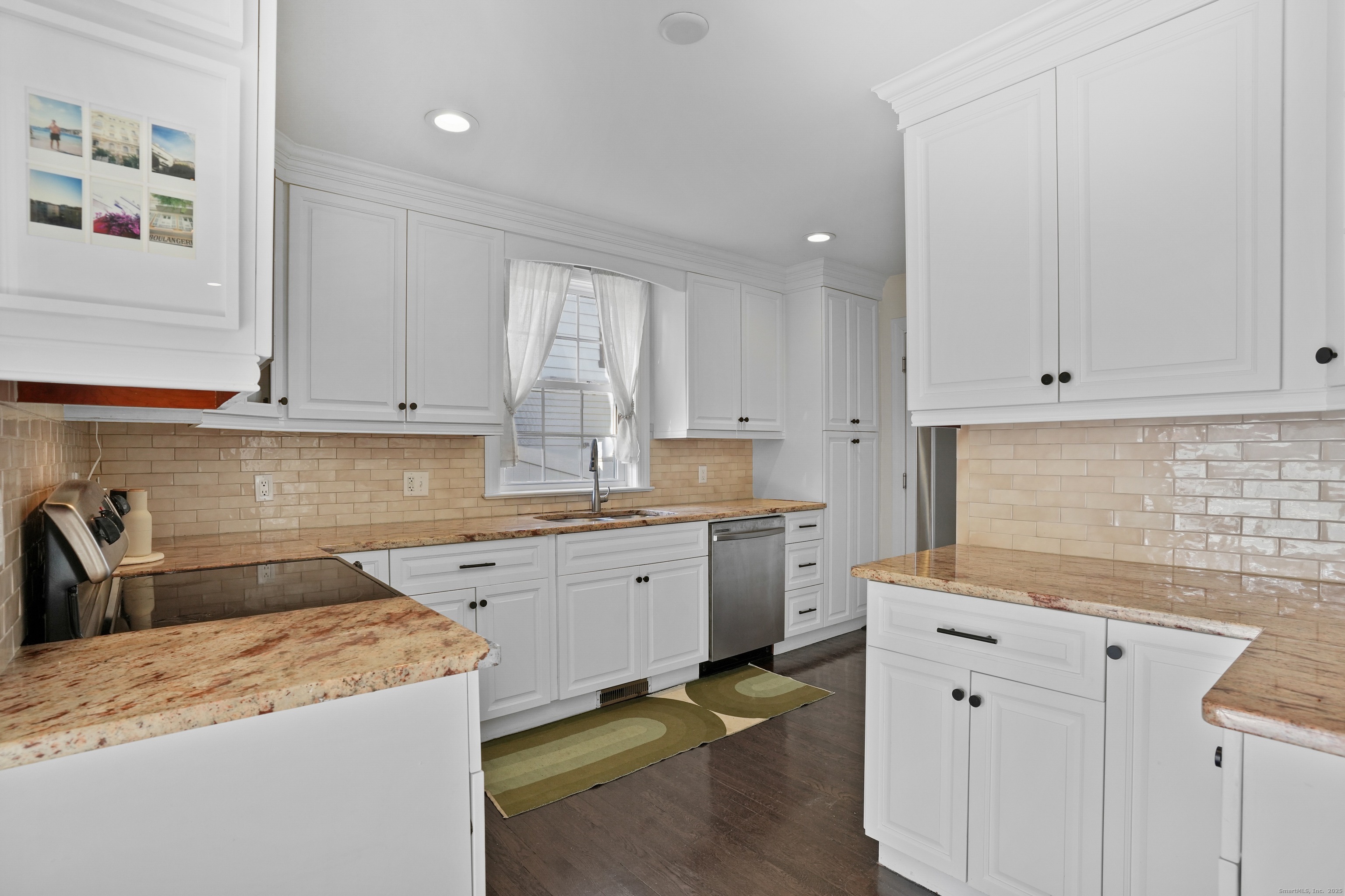 100 Hirsch Road Stamford, CT 06905 - Photo 8 of 39 a kitchen with granite countertop white cabinets and white appliances