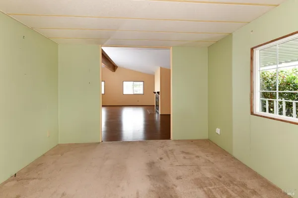 a view of an empty room with closet and cabinet