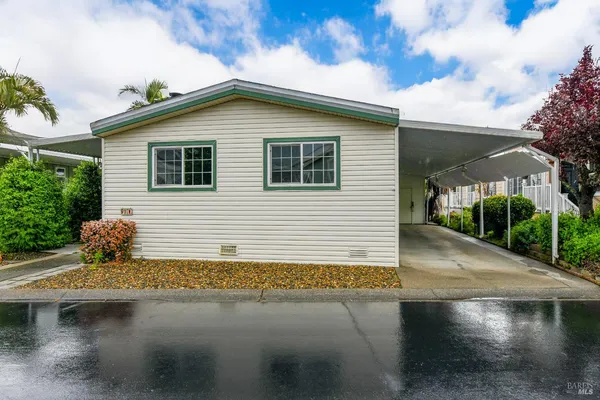 a yellow house with wooden fence next to a road