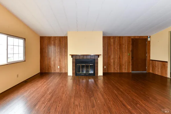 a view of a livingroom with wooden floor and stairs