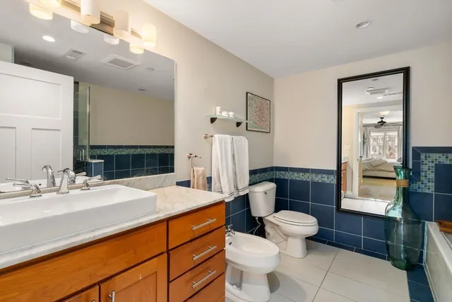 a bathroom with a sink a toilet a mirror and shower