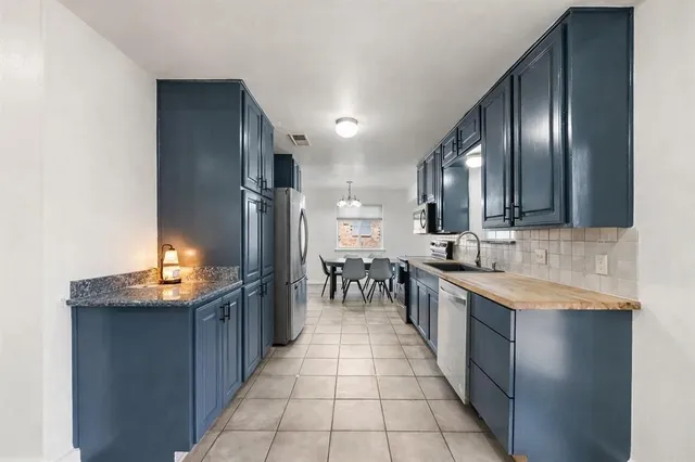 a kitchen with stainless steel appliances granite countertop a sink stove and cabinets