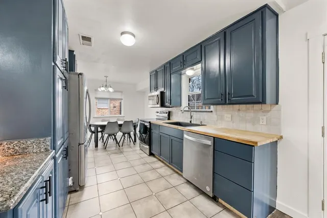 a large kitchen with stainless steel appliances granite countertop a stove and a sink
