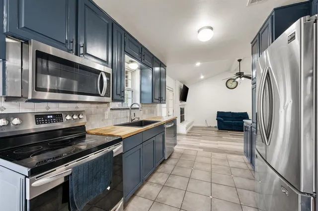 a kitchen with stainless steel appliances granite countertop a sink refrigerator and cabinets
