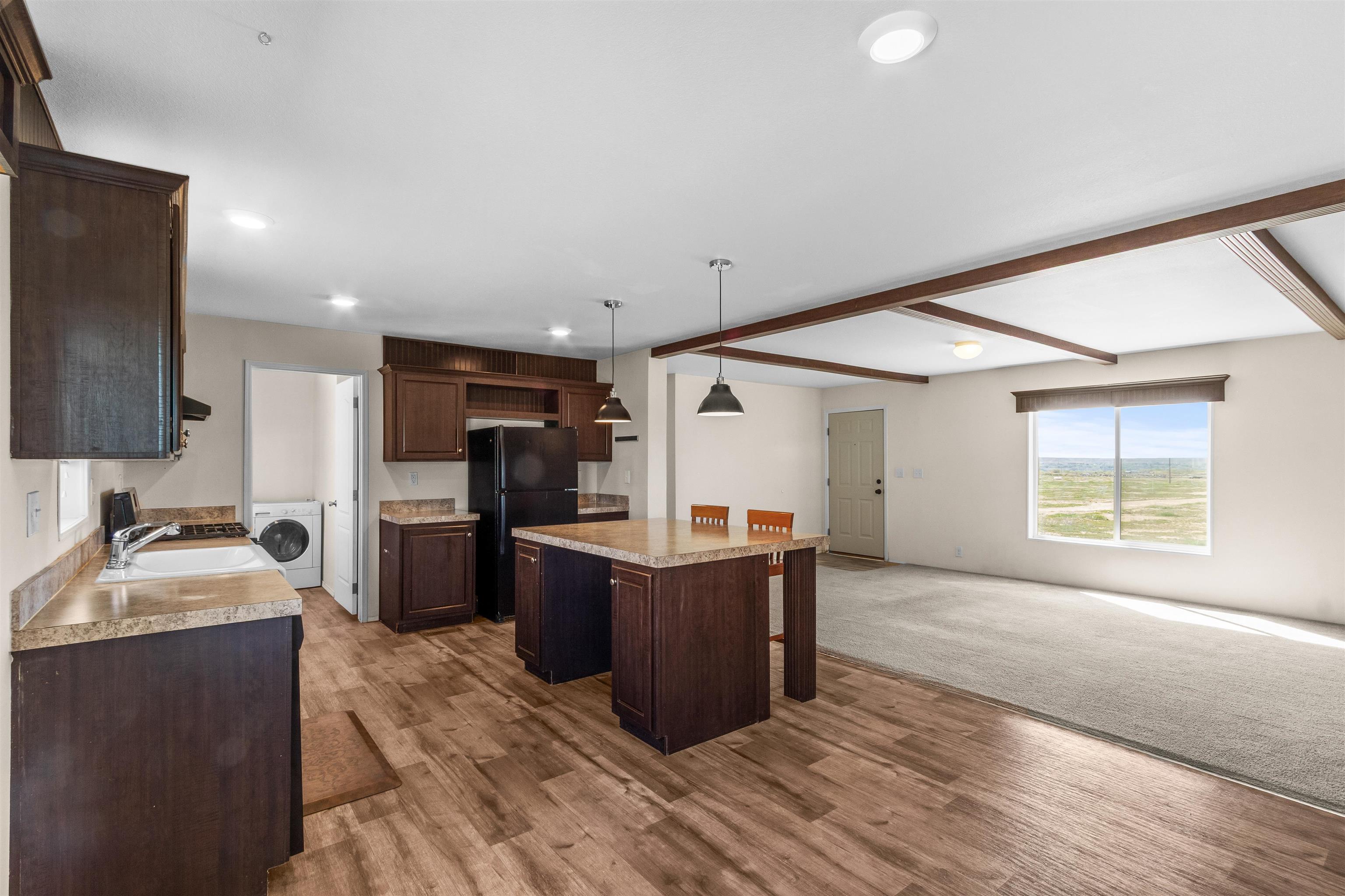 759 33 Road Clifton, CO 81520 - Photo 9 of 35 a room with kitchen island granite countertop wooden floors and stainless steel appliances