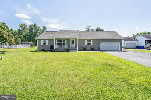 a view of a house with a yard and a large tree