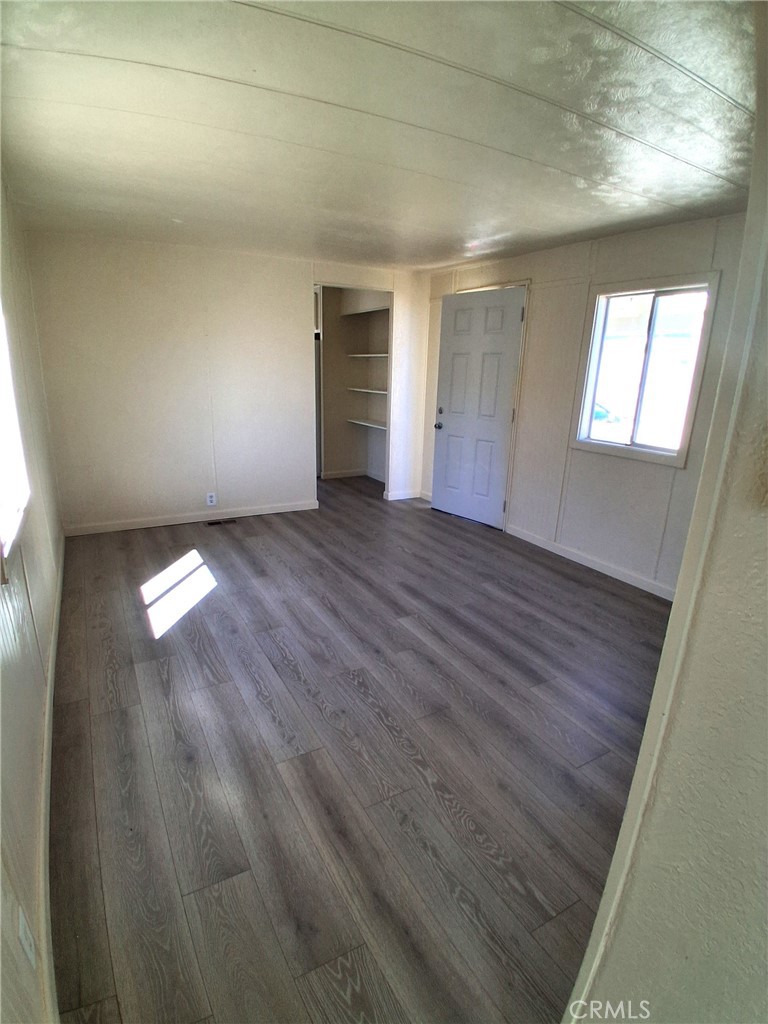 4561 Adobe Road, Unit 40 Twentynine Palms, CA 92277 - Photo 11 of 29 an empty room with wooden floor and windows