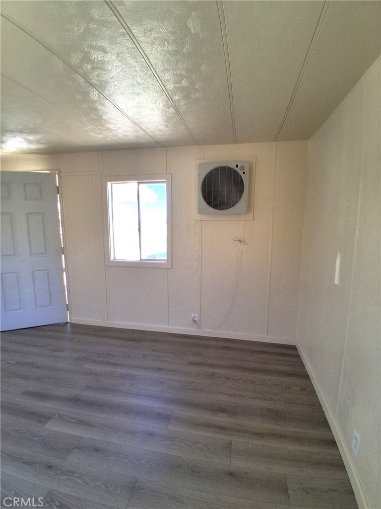 4561 Adobe Road, Unit 40 Twentynine Palms, CA 92277 - Photo 12 of 29 a view of an empty room with wooden floor and a window