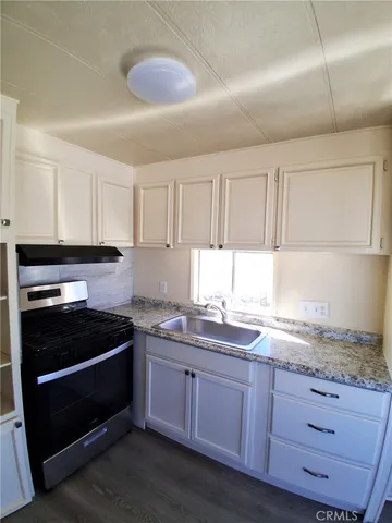 a white refrigerator freezer and a stove sitting inside of a kitchen