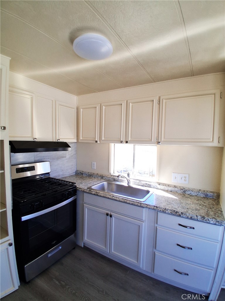 4561 Adobe Road, Unit 40 Twentynine Palms, CA 92277 - Photo 17 of 29 a kitchen with granite countertop wooden cabinets and white appliances