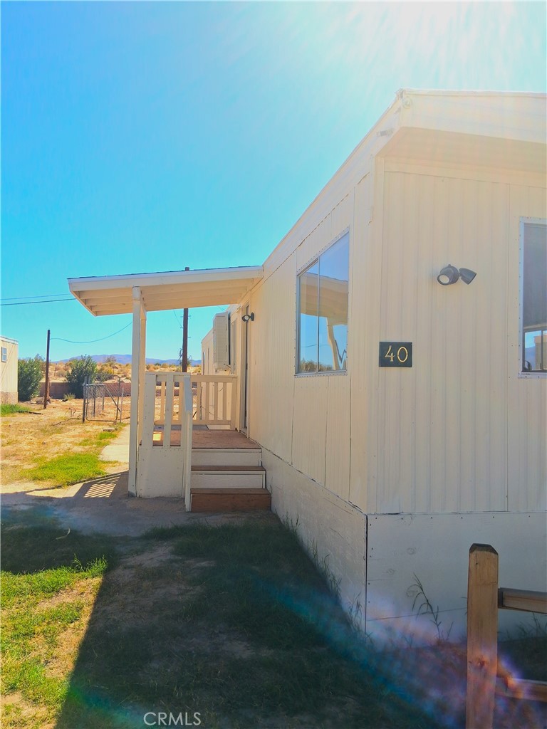 4561 Adobe Road, Unit 40 Twentynine Palms, CA 92277 - Photo 2 of 29 a view of swimming pool with lawn chairs under an umbrella