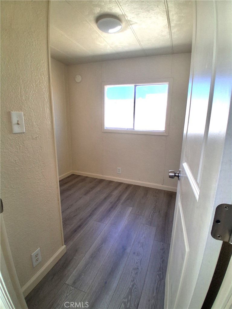 4561 Adobe Road, Unit 40 Twentynine Palms, CA 92277 - Photo 21 of 29 an empty room with wooden floor and windows